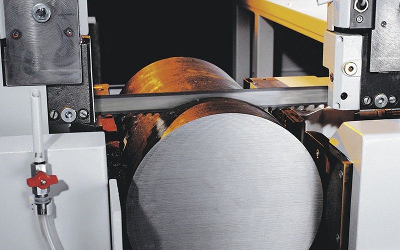 Band saw cutting a titanium round bar